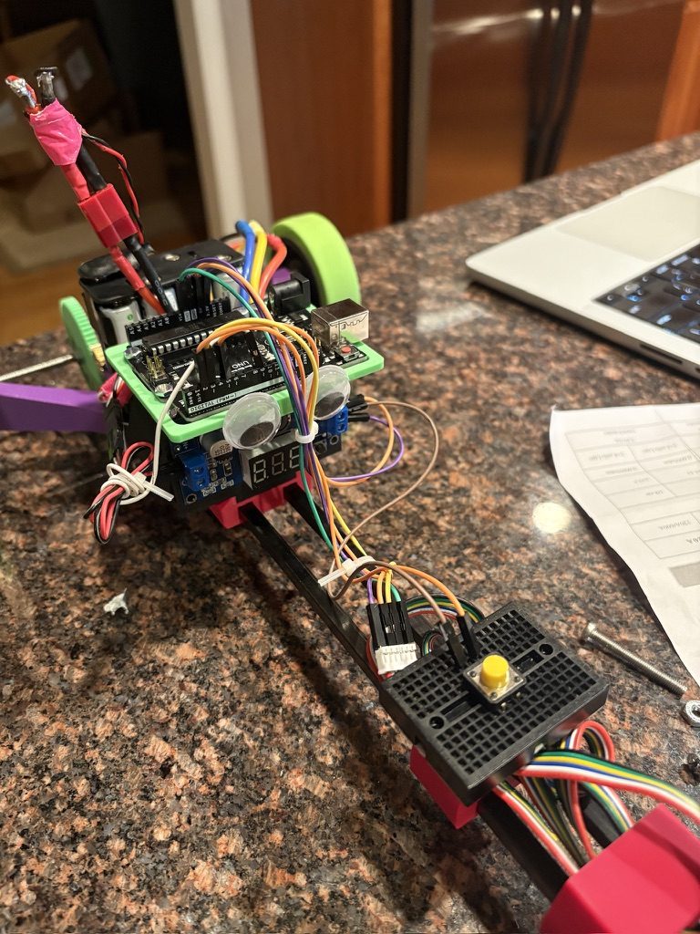 Science Olympiad electric vehicle with an Arduino, ultrasonic sensors, and a breadboard trigger.